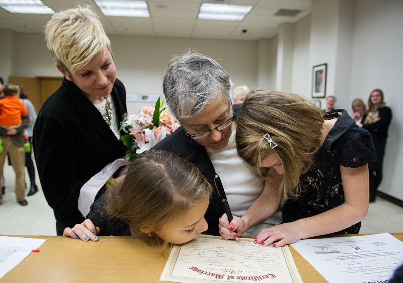 Leanne Corcoran and Rachel Ligtenberg watch as their young daughters sign the marriage certificate.