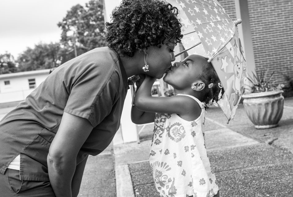 Nikki Brown and her daughter Kristian, 4-years-old, share a moment under an umbrella outside church in Chattanooga, TN on August 21, 2013.